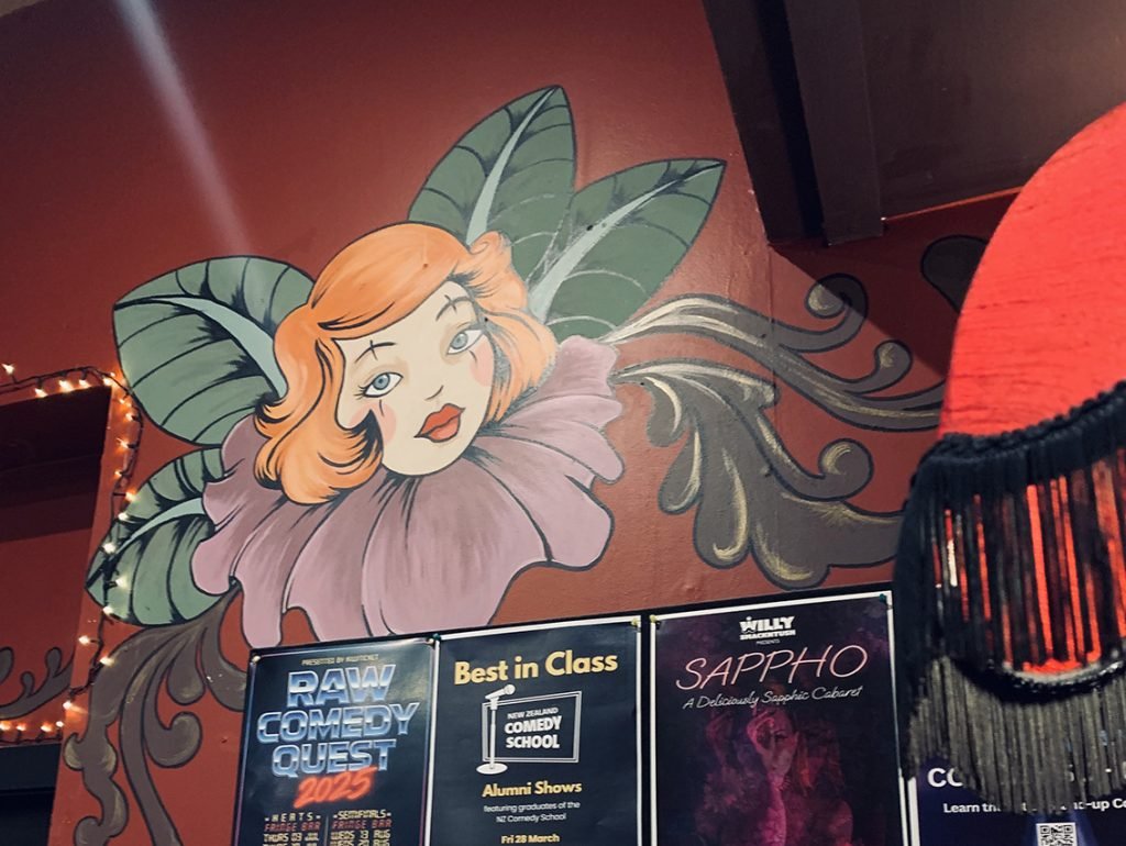 Whimsical painted mural of a flower-faced woman with orange hair and large green leaves at the Fringe Bar in Wellington